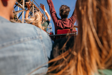 Friends on roller coaster ride at amusement park