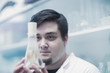 © Connect Images - Scientist examining sample in beaker