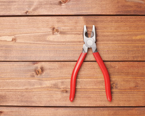 Wall Mural - Lineman's combination pliers hand tool on wooden surface