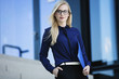 © Westend61 - Portrait of blond businesswoman with folder