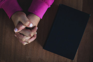 girl praying with her bible on table