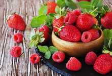 Ripe Red Raspberries And Strawberries In Wooden Bowl, Selective Focus