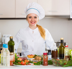 Wall Mural - Happy cook preparing vegetable salad with cheese