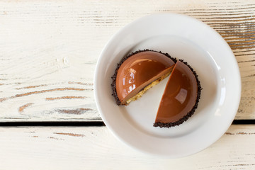 Dessert of brown color. Sweet dish with mirror icing. Delicious chocolate mousse cake. Dome shaped candy with filling.