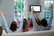 © WavebreakmediaMicro - Family raising hands while watching television