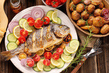 Grilled Fish With Roasted Potatoes And Vegetables On The Plate