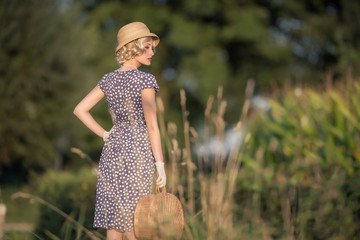 Retro 1930s summer fashion woman with blue dress and straw hat s