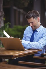 Poster - Handsome businessman using laptop and digital tablet