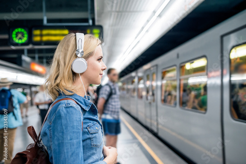 Fotografie, Obraz Young woman in denim shirt at the underground platform, waiting