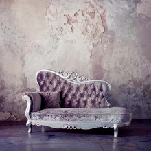 Grunge Styled Interior. Beautiful Sofa In Classical Style On A Background Of Textured Walls. Purple Toning