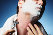 © Eric Hood - Closeup miserable male man shaving with razor burn bumps nicks cuts rash easily isolated