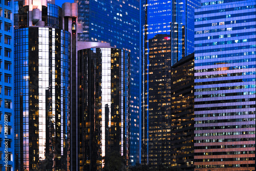 Mirrored downtown Los Angeles skyscrapers reflecting deep blue twilight sky with lighted windows © Eric Hood