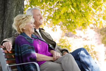 Senior couple relaxing together on a sunny autumn day at park