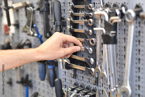 Fotografía Hand eines Mechanikers greift nach Werkzeug zur Reparatur