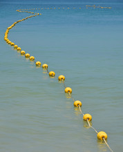 Chain Of Yellow Buoys In Blue Sea Water