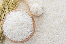 White Rice In Bowl And A Bag, A Wooden Spoon And Rice Plant On White Rice Background, Top View With Copy Space