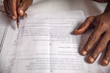 Hands of a farmer in India who fills out an application in Hindi language asking for infrastructure support for his village from the government