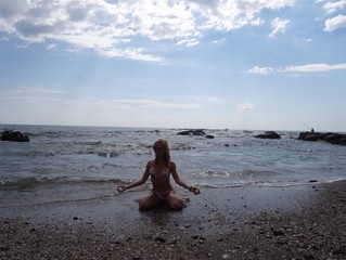 woman does yoga exercise near the ocean