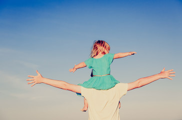 father and little daughter play at sky