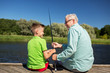 © Syda Productions - grandfather and grandson fishing on river berth