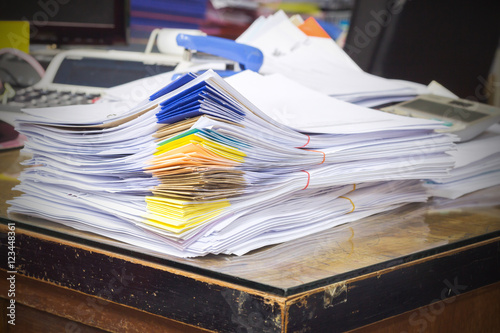 Fotografía Pile of documents on desk stack up high waiting to be managed