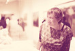 Portrait of retiree woman attentively looking at sculptures