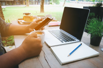 Man use mobile phone and holding coffee cup with laptop blank sc