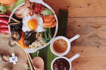 Wall Mural - Bibimbap korean food is delicious on wood background.