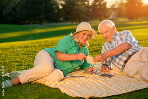 Senior People Lying On Meadow Couple Looking At Photograph I Remember This Day Bring Back Old Memories Stock Photo Adobe Stock
