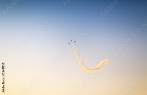 Foto Silhouette of airplanes performing acrobatic flight at sundown