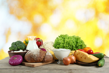 Fototapete - Vegetables and dairy products on blurred background
