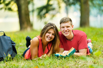 pair successful students with a textbook in a Park on a Sunny day