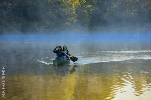 Fotografie, Obraz Mother and daughter canoeing in morning mist, North Carolina