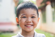 Close up portrait of asian boy smiling in the park.