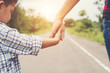 © Johnstocker - Mother holding hand of her son outdoors in summer walking on the