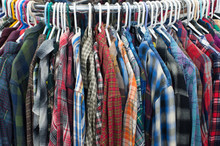Thrift Store Flannel Shirts On A Clothing Rack