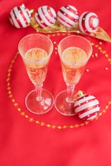 Wall Mural - Christmas table with red cloth and decorations with two glasses of champagne