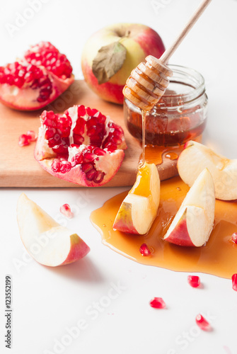 Plakat Granat, jabłka i miód na białym stole - tradycyjne symbole żydowskiego Nowego Roku, Rosz Haszana. Selektywne fokus i zamknij