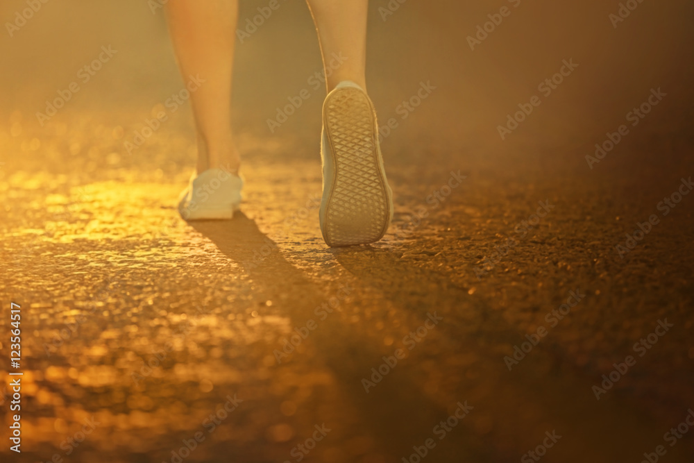 Female legs on asphalt background