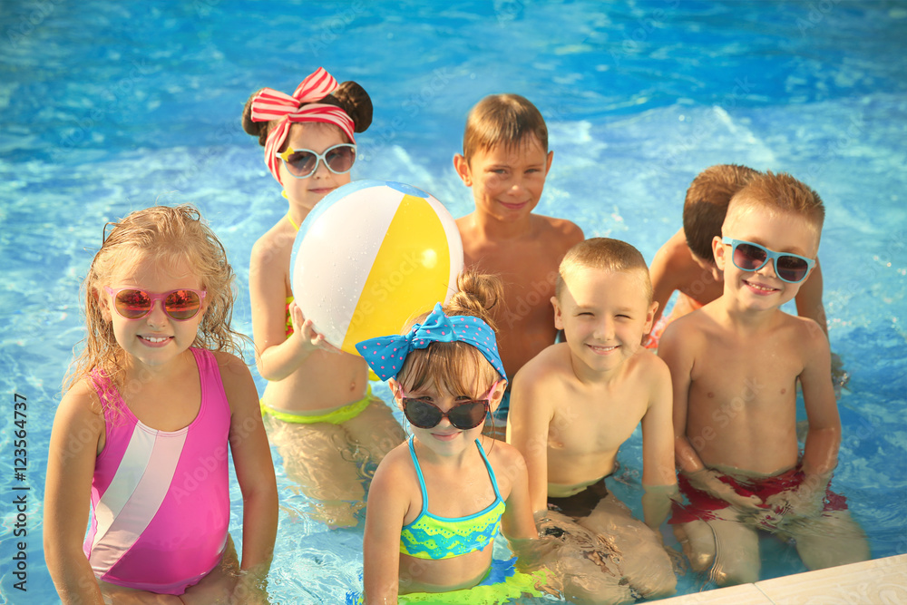 Little kids at swimming pool on sunny day