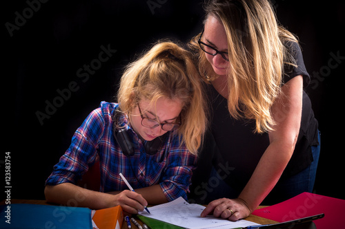 Plakat matka pomaga jej nastoletniej córce w odrabianiu prac domowych