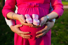 Pregnant Woman And Her Husband Holding Baby Shoes