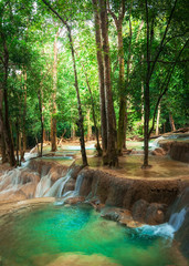  Jangle landscape with amazing turquoise water of Kuang Si cascade waterfall at deep tropical rain forest. Luang Prabang, Laos travel landscape and destinations