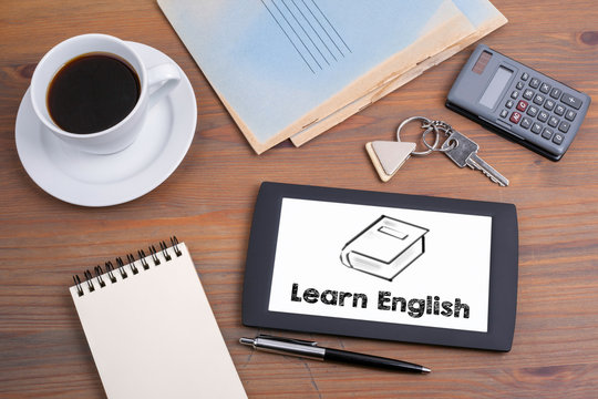 Learn English, business concept. Text on tablet device on a wood