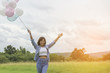 © sunti - Happy beautiful young woman standing holding colorful of balloon