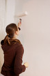 © marreston - young woman painting her home wall. Handmade