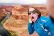 Young tourist taking a photo of herself by famous Horseshoe Bend, Arizona