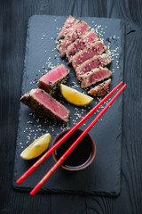 Poster - Fresh fried tuna fillet with sesame sliced on a stone slate tray