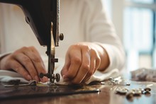 Female Dressmaker Sewing In The Studio