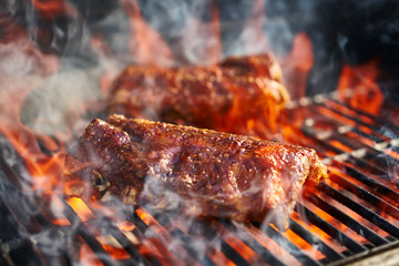 bbq pork ribs cooking on flaming grill